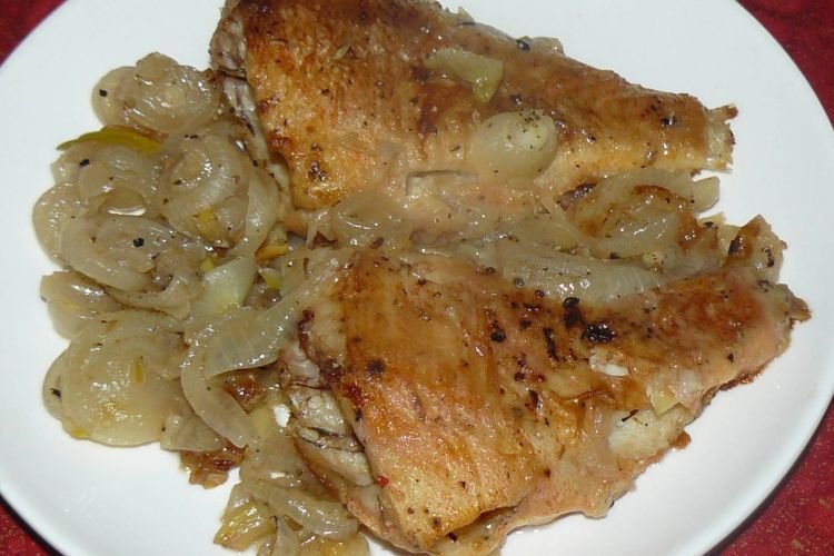 Морской окунь с луком на сковороде